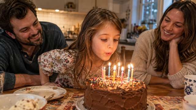 A 360p video frame of a child blowing out birthday candles